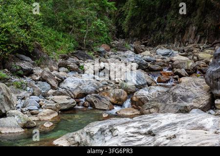 Ruisseau de Sanzhanxi au parc national de Taroko. L'eau claire coule sur un lit rocheux avec des arbres verts. Paysage de forêt naturelle à Hualien, Taïwan. Banque D'Images