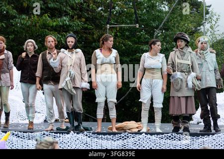 CAST DE SPECTACLE EN PLEIN AIR ALIGNÉ SUR SCÈNE, ARTS VIVANTS ET DANSE, FESTIVAL GREEN MAN, BRECON, PAYS DE GALLES, ROYAUME-UNI : Un groupe divers de performers masculins et féminins en costumes théâtraux se tiennent en ligne sur une scène en plein air, face au public à la fin d'un spectacle. Citrus Arts et Circomedia jouent sur la scène du théâtre Back Of Beyond. Photo : Rob Watkins. INFO : Le festival Green Man a lieu chaque année dans les Brecon Beacons en août. Il célèbre la musique, les arts, la littérature, la science et une culture adaptée aux familles dans un magnifique cadre montagneux. Des artistes itinérants ajoutent à l'atmosphère dans les champs entre les cerfs Banque D'Images