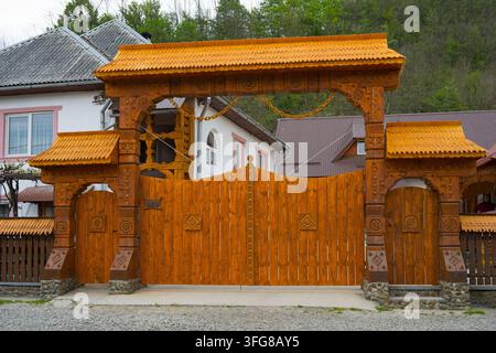 Grande porte en bois traditionnelle avec des sculptures détaillées dans un cadre de village, porte en bois traditionnelle à Barsana, Barsana, județ de Maramureș, Maramureș Banque D'Images