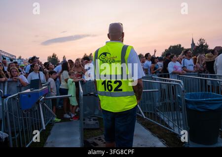 Un agent de sécurité se tient devant une foule au coucher du soleil lors d'un concert, Superjam Festival avec Stega Security, Waghaeusel, Allemagne Banque D'Images