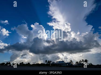 Soleil derrière les nuages du petit matin dans un ciel bleu au-dessus du sud-ouest de la Floride, États-Unis Banque D'Images