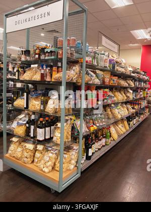Pforzheim Allemagne 29 août 2026 Étagère gondole métallique haute dans un rayon de magasin rempli de sacs transparents de pâtes, bocaux, bouteilles d'huile et de sauces, emballés Banque D'Images