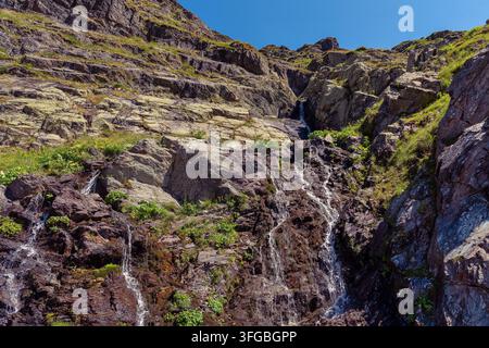 Petites cascades de montagne coulant le long d'une paroi rocheuse escarpée près de la Transfăgărășan en Roumanie Banque D'Images