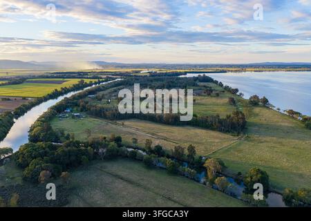 Vue aérienne du canal de Romiaka et de la rivière Clarence serpentant à travers les terres agricoles de Palmers Island près de Yamba, avec des champs cultivés et une végétation rurale Banque D'Images