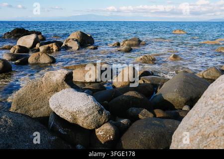 Côte rocheuse avec une mer bleue claire et des vagues Banque D'Images