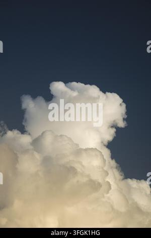 Un nuage cumulus blanc imposant s’élève contre un ciel marine sombre, représentant la liberté, la paix et la croissance spirituelle dans une atmosphère extérieure calme et sereine. Banque D'Images