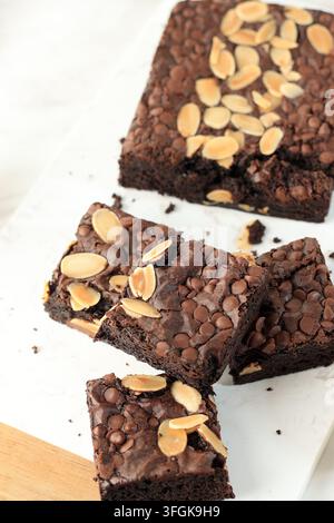 Brownies riches garnis de tranches d'amandes. Les bords friables et les pépites de chocolat ajoutent de la texture. Fraîchement coupés, ils ont l'air décadents et tentants. Parfaits pour des Banque D'Images