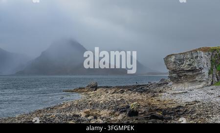 La côte rocheuse d'Elgol Beach sur l'île de Skye en Écosse, avec une vue sur les montagnes Cuillin au-dessus du Loch Scavaig. Banque D'Images