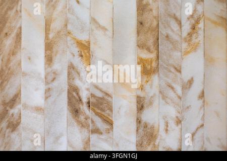Carreaux muraux effet marbre beige avec veines naturelles. Carreaux effet marbre beige et brun disposés en bandes verticales avec des veines naturelles douces et un Banque D'Images