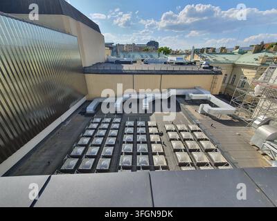 Vue en hauteur d'un toit de bâtiment commercial présentant plusieurs puits de lumière carrés disposés selon un motif géométrique en grille. Grands conduits d'aération en argent Banque D'Images