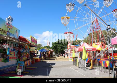 Une scène de carnaval vibrante au festival de Gladstone Harbour mettant en vedette une grande roue et des stands de divertissement sous un ciel bleu dans le Queensland, en Australie Banque D'Images