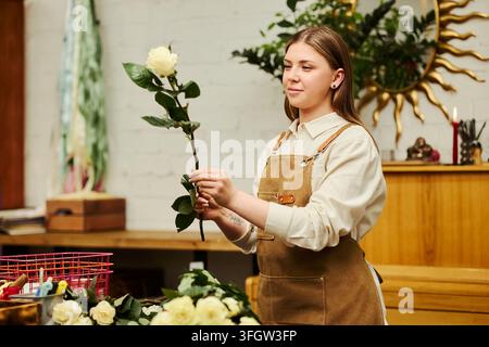 Fleuriste arrangeant des roses fraîches dans une boutique de fleurs Banque D'Images