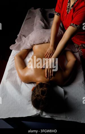 Thérapeute donne un massage relaxant du dos dans un spa Banque D'Images