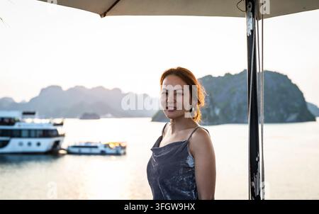 Femme profitant d'une croisière au coucher du soleil dans la baie d'Ha Long Banque D'Images