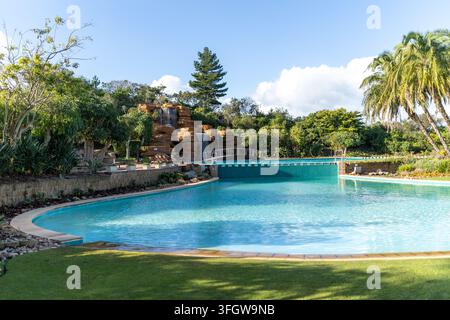 Piscine de resort avec cascade artificielle en roche et pont Banque D'Images