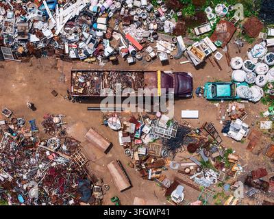 Vue aérienne d'un centre de recyclage métallique avec un gros camion chargé de ferraille, des piles de matériaux jetés et des déchets industriels à Tuxpan, Jali Banque D'Images