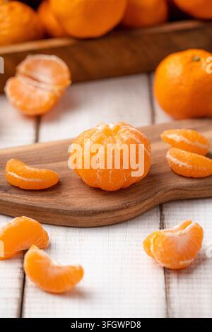 Oranges mandarine pelées sur une planche en bois Banque D'Images