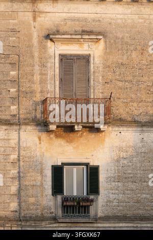 Anciens balcons et fenêtres fermées sur un bâtiment historique patiné à Matera, Basilicate, dans le sud de l'Italie. Banque D'Images