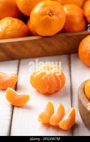 Oranges mandarine pelées sur une planche en bois Banque D'Images
