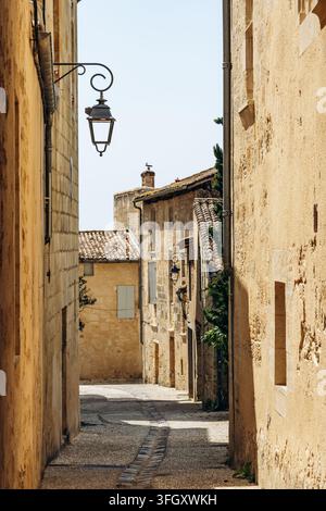 Rue historique étroite à Saint Emilion bordée de bâtiments en calcaire et de lanternes traditionnelles Banque D'Images