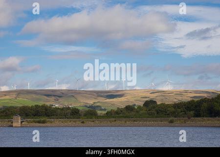 Éoliennes lointaines se dressant fièrement sur les collines des Pennines, surplombant les eaux pittoresques du lac Hollingworth, Rochdale, Royaume-Uni. Banque D'Images