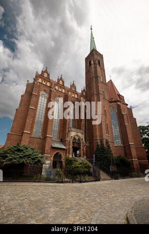 L'extérieur en briques gothique de la Collégiale du Saint-Sacrement et de Saint-Barthélemy s'élève au-dessus de la place de l'église sur Ostrow Tumski. Banque D'Images