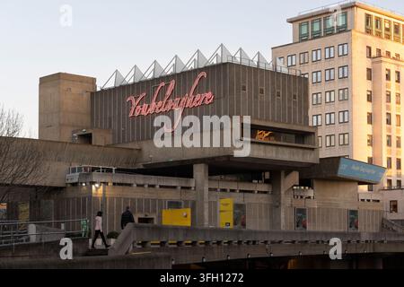 Des gens passent devant la Hayward Gallery du Southbank Centre à Londres en hiver, présentant l'installation artistique au néon lumineuse "You Belong Here". Banque D'Images