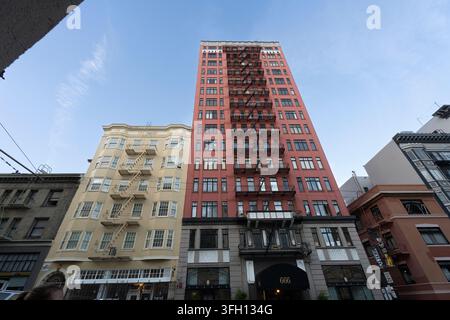 Vue en contre-plongée mettant en valeur l'architecture de l'immeuble historique 666 et les escaliers de secours le long d'une rue de San Francisco. Banque D'Images