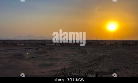 Soleil éclatant brillant sur un paysage désertique au coucher du soleil. Banque D'Images
