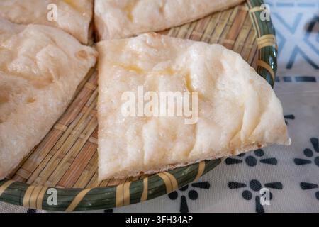 Close-up de tranches de pain naan indien fraîchement cuit, servi sur une assiette tissée. Banque D'Images