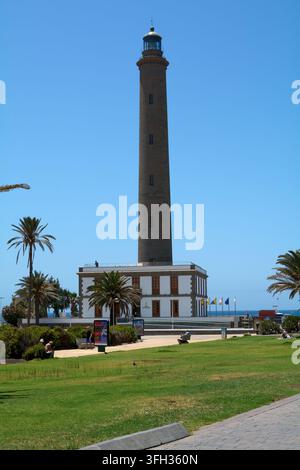 Las Palmas, Espagne – 15 septembre 2026 : Le phare historique de Faro de Maspalomas se dresse fièrement contre un ciel bleu clair, entouré de palmiers et Banque D'Images