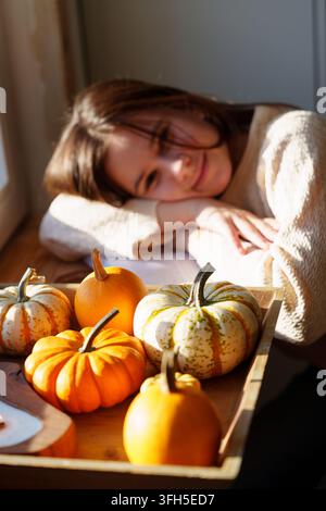 Nature morte d'automne avec citrouilles et une adolescente floue en arrière-plan Banque D'Images