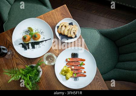 Plats gastronomiques délicieux servis avec élégance sur une table en bois dans un cadre chaleureux Banque D'Images