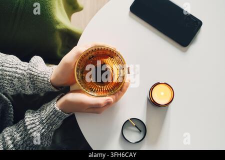 Rituel du soir tranquille avec du thé et la lumière des bougies. Concept de détox numérique Banque D'Images