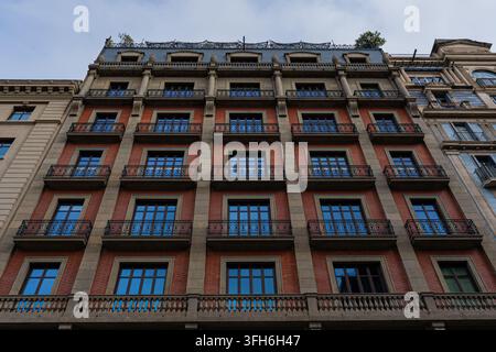 Vue extérieure détaillée d'une façade de bâtiment historique ancien présentant une architecture en pierre traditionnelle, des balcons décoratifs et des fenêtres classiques à B Banque D'Images