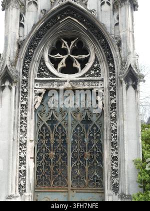 PARIS APR 5, 2026 Entrée de mausolée en pierre sculptée ornée d'un rosace et d'une porte en fer forgé délabrée dans un cadre de cimetière historique. , Pere Banque D'Images