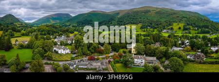 Vue aérienne du village de Grasmere entouré de campagne verdoyante dans le Lake District ; idéal pour les voyages au Royaume-Uni, le tourisme, l'immobilier et le marketing de destination Banque D'Images
