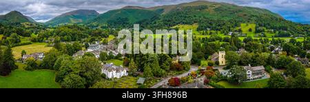 Vue aérienne du village de Grasmere entouré de campagne verdoyante dans le Lake District ; idéal pour les voyages au Royaume-Uni, le tourisme, l'immobilier et le marketing de destination Banque D'Images