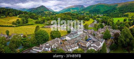 Vue aérienne du village de Grasmere entouré de campagne verdoyante dans le Lake District ; idéal pour les voyages au Royaume-Uni, le tourisme, l'immobilier et le marketing de destination Banque D'Images