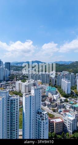 Vue aérienne de Haeundae-gu à Busan, en Corée du Sud, mettant en valeur les immeubles résidentiels modernes en hauteur, le développement urbain dense et les collines verdoyantes Banque D'Images