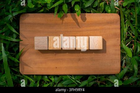 Cinq cubes en bois sur une planche en bois rustique Fond minimal plat Banque D'Images