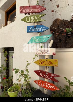 Panneau de destination coloré à Ohrid, Macédoine du Nord, indiquant les distances vers Kaneo Beach, Cuba, Santorin, Bali, la Suisse, Venise et la vieille ville Banque D'Images