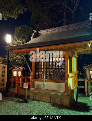 Pavillon traditionnel d'un sanctuaire shintoïste japonais illuminé avec une corde de cloche la nuit à Kyoto, Japon. Banque D'Images