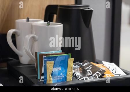 Szklarska Poręba, Pologne - 15 décembre 2025 : Paquets de boissons Segafredo Zanetti disposés sur un plateau de chambre d'hôte avec des tasses en céramique et une bouilloire pour le Banque D'Images