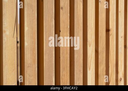 Close-up détaillé d'un mur en lattes de pin naturel avec des lignes verticales et des ombres distinctes, parfait pour des arrière-plans élégants, la conception intérieure et c Banque D'Images
