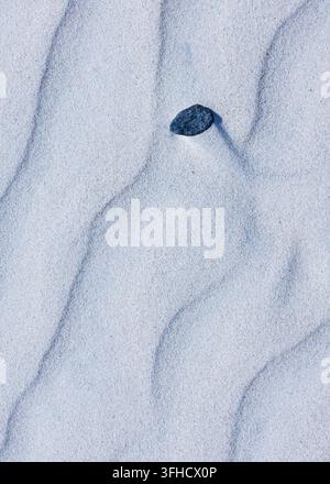 Gros plan abstrait de motifs parfaits de rides de vent dans des dunes de sable blanc formant des vagues douces Banque D'Images