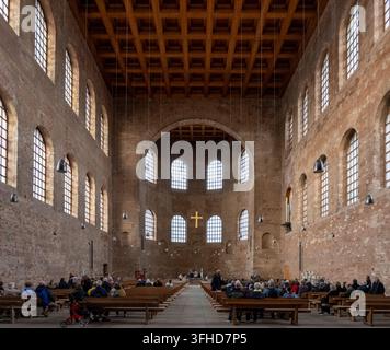 Vue intérieure large de la basilique Constantin à Trèves avec des murs en briques, des bancs en bois, des fenêtres cintrées et une croix dorée. Banque D'Images