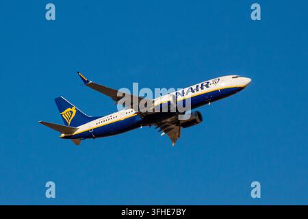Un Boeing 737 MAX de Ryanair, immatriculation 9H-VUG, monte après avoir décollé de l'aéroport de Madrid-Barajas, le train d'atterrissage encore déployé contre un ciel clair Banque D'Images