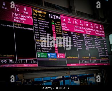 Les informations de retard en rouge sur les panneaux de départ de Manchester Piccadilly pour les quais 13 et 14 mettent en évidence la pression exercée sur le couloir ferroviaire de Castlefield. Banque D'Images