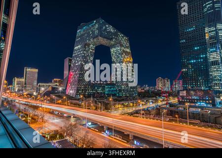 Vue nocturne du siège de CCTV à Pékin avec les lumières des routes de la ville brillant intensément Banque D'Images